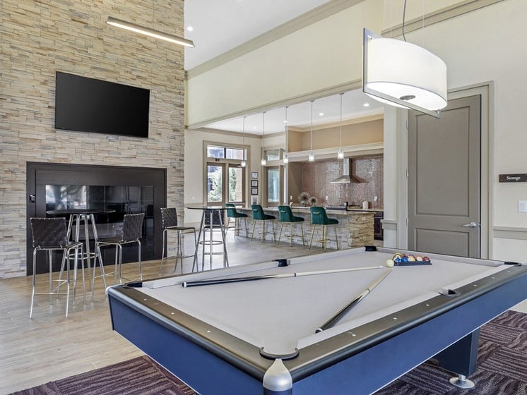 a clubhouse with a pool table and a fireplace